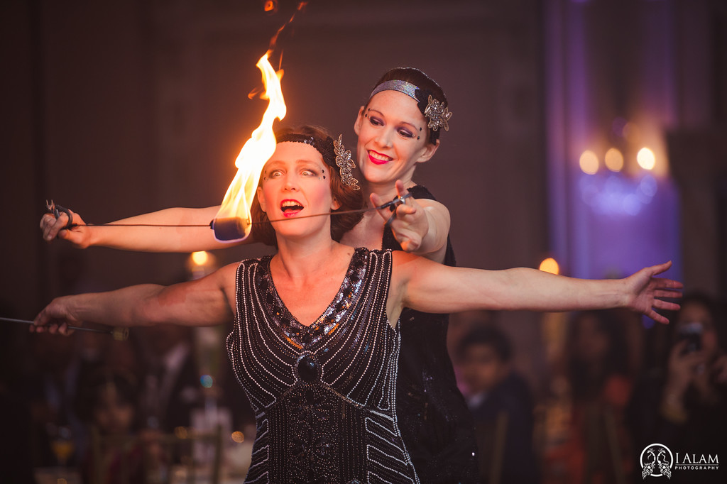 2 women in 1920s costumes with fire orb in front of their astonished faces