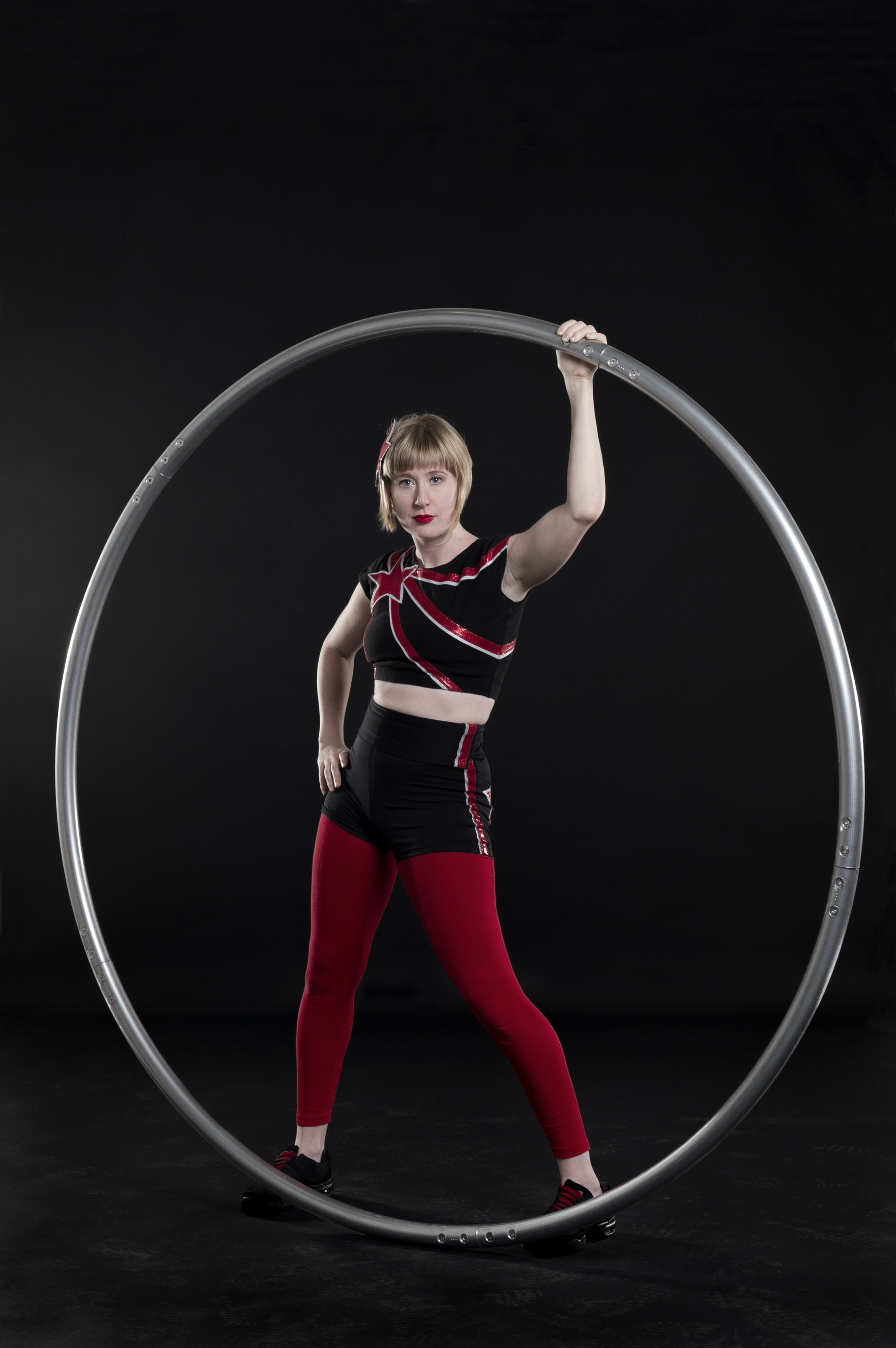 bex in motion posing with a cyr wheel