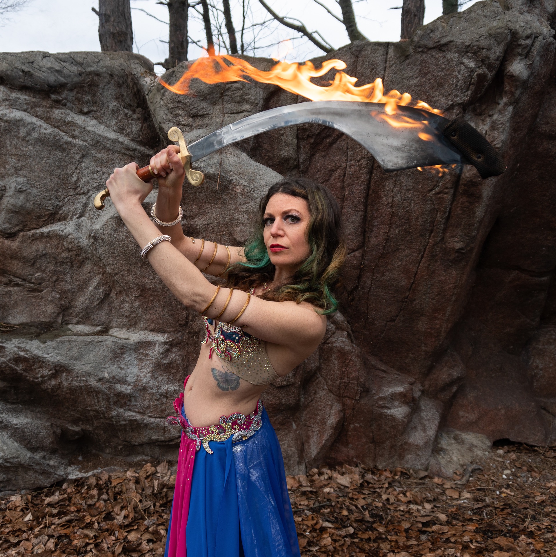 belly dancer with fire sword held aloft in the air